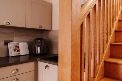 a small kitchen with a staircase in a tiny house at Ellenboro House, Cosy Sleeps 2, Near Cartmel in Grange Over Sands