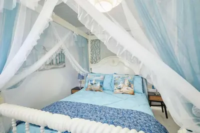 a bedroom with a canopy bed with two dogs on pillows at Host & Stay - The Cheeky Squirrel in New Brighton