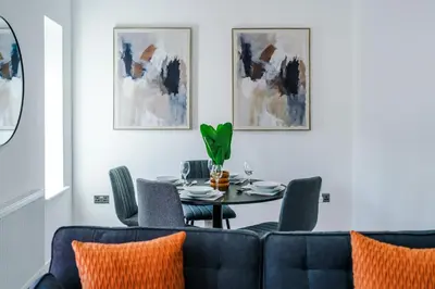 a dining room with a blue couch and a table at Modern 2BR Flat with Parking, Fully Equipped, Sleeps 4 in Liverpool