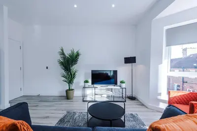 a living room with a couch and a tv at Modern 2BR Flat with Parking, Fully Equipped, Sleeps 4 in Liverpool