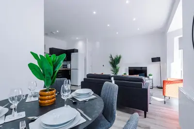 a living room with a table and chairs and a couch at Modern 2BR Flat with Parking, Fully Equipped, Sleeps 4 in Liverpool