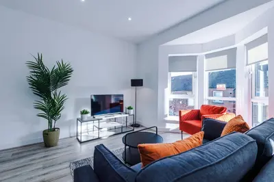 a living room with two blue couches and a tv at Modern 2BR Flat with Parking, Fully Equipped, Sleeps 4 in Liverpool