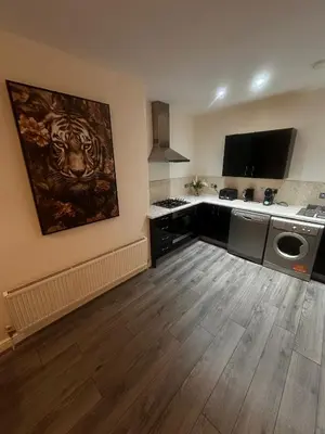 a room with a kitchen with a large painting on the wall at Spacious City Centre 2-Bedroom Apartment by StaySavvy Accommodation in Liverpool