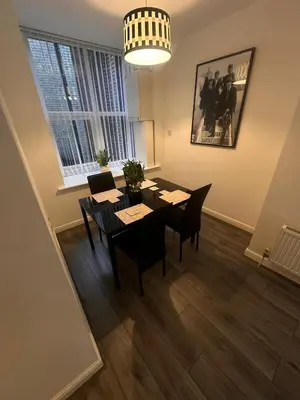 a dining room with a table and chairs and a window at Spacious City Centre 2-Bedroom Apartment by StaySavvy Accommodation in Liverpool
