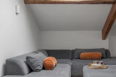 a living room with a gray couch with orange pillows at Ford Park House Penthouse Escape in Ulverston