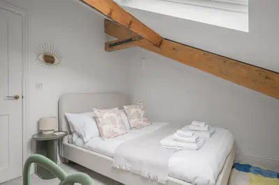 a bedroom with a bed with white sheets and pillows at Ford Park House Penthouse Escape in Ulverston