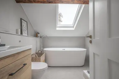 a bathroom with a tub and a toilet and a window at Ford Park House Penthouse Escape in Ulverston