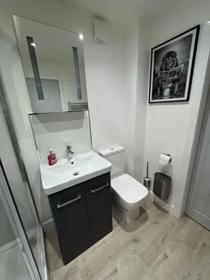 a bathroom with a sink and a toilet and a mirror at Cosy Modern 2 Beds Chorley Center in Chorley