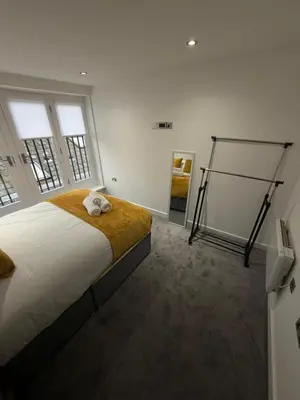 a bedroom with a bed with a cat laying on it at City Centre Duplex Apartment Liverpool in Liverpool