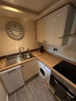 a kitchen with a sink and a clock on the wall at City Centre Duplex Apartment Liverpool in Liverpool