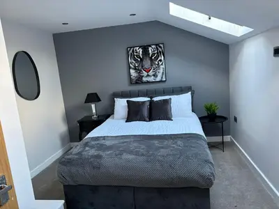 a bedroom with a king sized bed with blue walls at City Centre Duplex Apartment Liverpool in Liverpool
