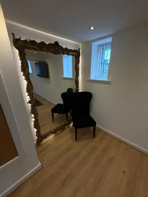 a living room with a mirror and a chair at City Centre Duplex Apartment Liverpool in Liverpool
