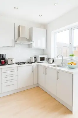 a white kitchen with white cabinets and a sink at Platt Bridge Contractor Stays-2 bedroom house in Abram