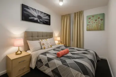 a bedroom with a bed with a orange pillow on it at Platt Bridge Contractor Stays-2 bedroom house in Abram