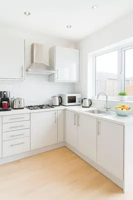 a white kitchen with white cabinets and a sink at Platt Bridge Contractor Stays-2 bedroom house in Abram