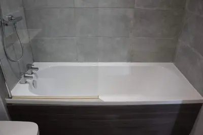 a white bath tub in a bathroom with a shower at Melbourne House Gem Stylish 2-Bed in City Centre in Accrington