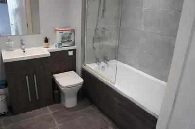 a bathroom with a shower and a toilet and a sink at Melbourne House Gem Stylish 2-Bed in City Centre in Accrington