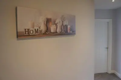 a shelf with vases and candles on a wall at Melbourne House Gem Stylish 2-Bed in City Centre in Accrington