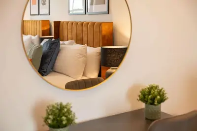a mirror reflecting a couch in a living room at Modern 3 beds APT, 2 Baths, Free Parking in Liverpool