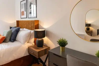 a bedroom with a bed and a table with a mirror at Modern 3 beds APT, 2 Baths, Free Parking in Liverpool