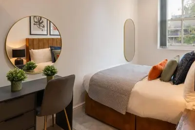 a bedroom with a bed and a desk and a mirror at Modern 3 beds APT, 2 Baths, Free Parking in Liverpool