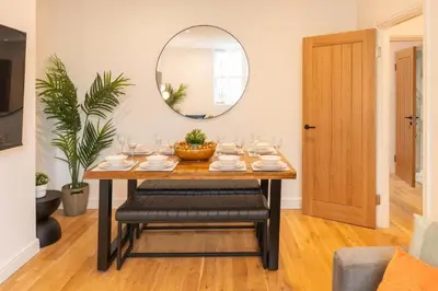 a dining room with a table and a mirror at Modern 3 beds APT, 2 Baths, Free Parking in Liverpool