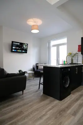 a living room with a washing machine in the middle at Antrim House by Serviced Living Liverpool in Liverpool