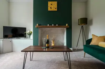 a living room with a table and a fireplace at Ribby Stays - 2 bed Cottage Pet Friendly in Wrea Green