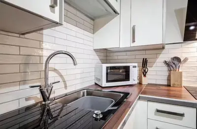 a kitchen with a sink and a microwave at Ribby Stays - 2 bed Cottage Pet Friendly in Wrea Green
