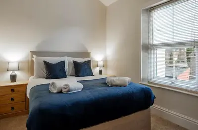 a bedroom with a large bed with towels on it at Ribby Stays - 2 bed Cottage Pet Friendly in Wrea Green