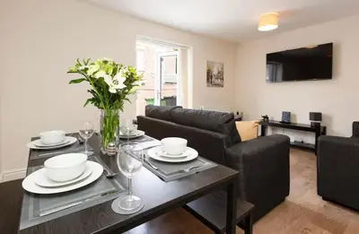 a living room with a table with a vase of flowers at Oxheys Stays - Sleeps 7 - Home from Home in Preston