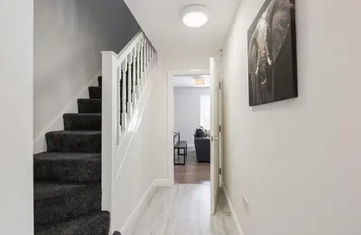 a staircase in a home with white walls and gray stairs at Oxheys Stays - Sleeps 7 - Home from Home in Preston
