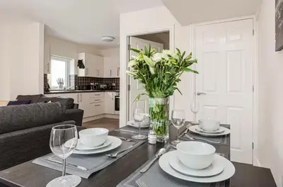 a dining room table with a vase of flowers and wine glasses at Oxheys Stays - Sleeps 7 - Home from Home in Preston
