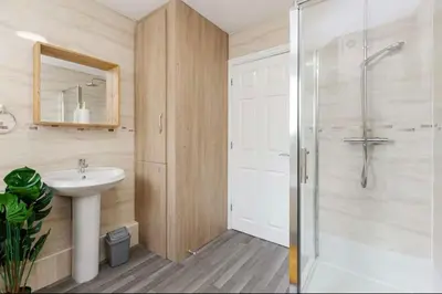 a bathroom with a shower and a sink and a mirror at Oxheys Stays - Sleeps 7 - Home from Home in Preston