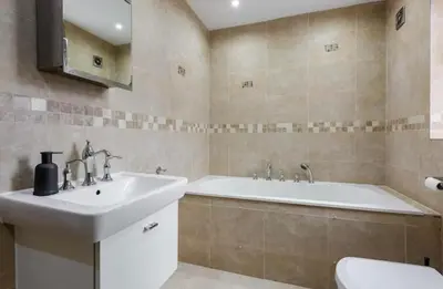 a bathroom with a sink and a tub and a toilet at Albert Stays - 5 bed Sleeps 11 - Free Parking in Preston