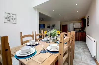 a wooden dining room table with chairs and a tableastery at Albert Stays - 5 bed Sleeps 11 - Free Parking in Preston
