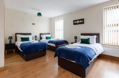 a bedroom with two beds with blue and white sheets at Albert Stays - 5 bed Sleeps 11 - Free Parking in Preston