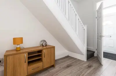 a room with a wooden dresser and a staircase at Connaught Stays - Home from Home - Sleeps 7 - Free Wifi in Preston