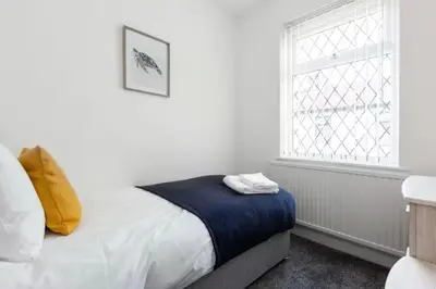 a bedroom with a bed and a window at Connaught Stays - Home from Home - Sleeps 7 - Free Wifi in Preston