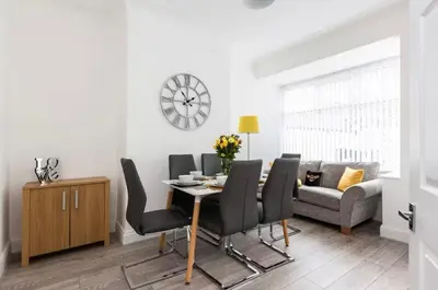 a dining room with a table and chairs and a couch at Connaught Stays - Home from Home - Sleeps 7 - Free Wifi in Preston