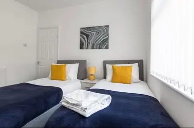 two beds sitting next to each other in a room at Connaught Stays - Home from Home - Sleeps 7 - Free Wifi in Preston