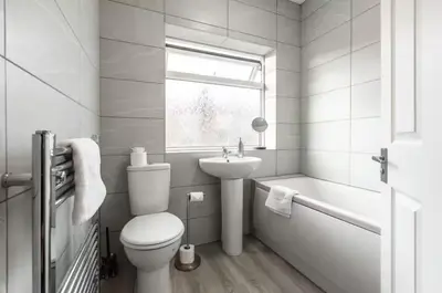 a white bathroom with a toilet and a sink at Connaught Stays - Home from Home - Sleeps 7 - Free Wifi in Preston