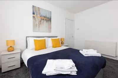 a bedroom with a large bed with towels on it at Connaught Stays - Home from Home - Sleeps 7 - Free Wifi in Preston