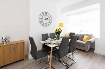 a dining room with a table and black chairs at Connaught Stays - Home from Home - Sleeps 7 - Free Wifi in Preston