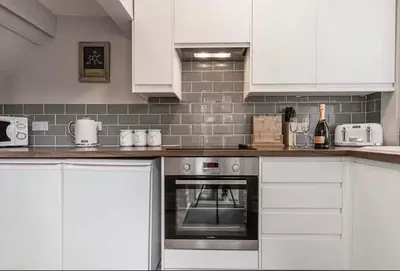 a kitchen with white cabinets and an oven at Carnarvon Stays - 2 bed Family Home - Free WiFi in Preston