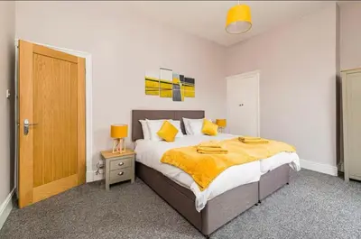 a bedroom with a large bed with yellow sheets at Carnarvon Stays - 2 bed Family Home - Free WiFi in Preston
