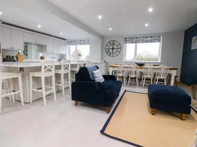 a kitchen and living room with chairs and a table at Brook House in Preston