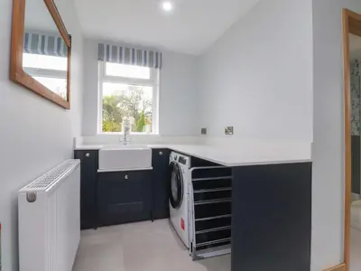 a laundry room with a sink and a washing machine at Brook House in Preston