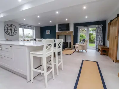 a kitchen with a white counter and stools at Brook House in Preston
