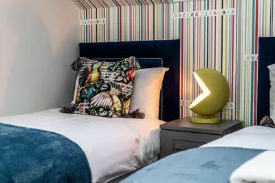 a bedroom with a bed and a lamp on a night stand at 3BR Georgian Quarter Coach Houses - Private Parking in Liverpool